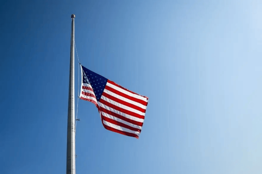 American flag flying at half-staff on a clear day